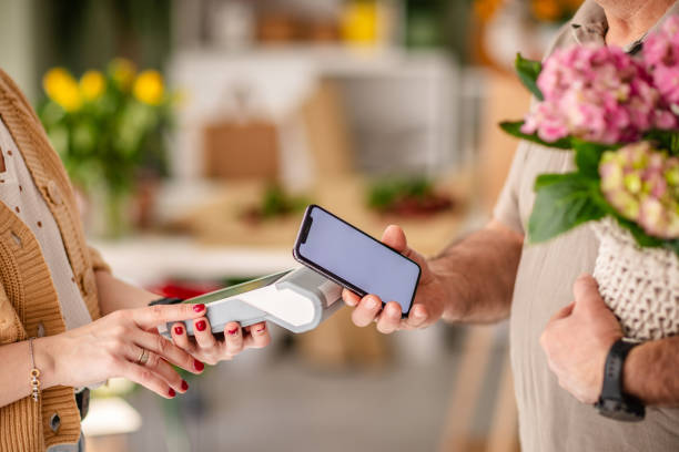 istock Payment for flowers using modern wireless technology at a bustling flower shop gifting experience 2204364361