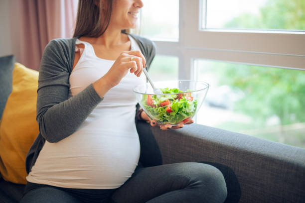 istock Expecting mother enjoying a healthy vegetable salad at home. 2204364372