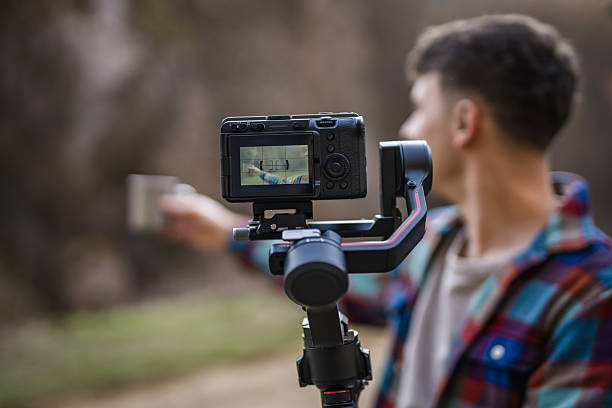 istock close up on male hands hold camera with stabilizer and filming 2204364710