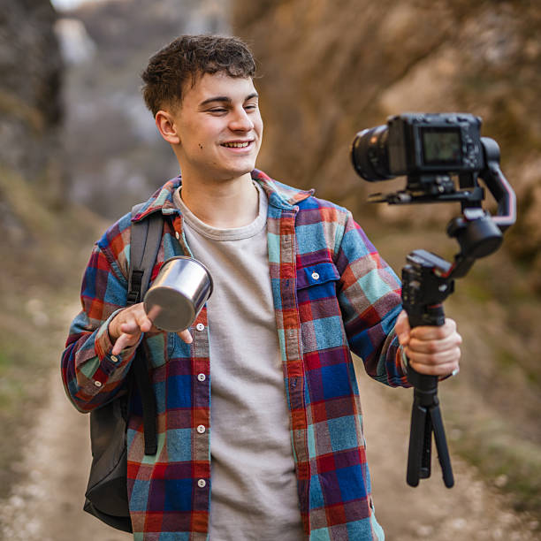 istock Man hiker making video on camera with stabilizer show cup on footpath 2204365334