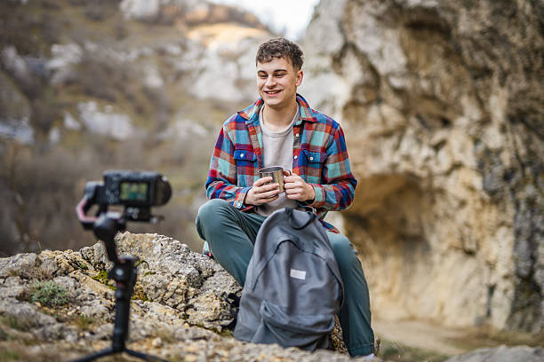 istock Man hiker kneel and making video on camera with stabilizer show cup 2204365707