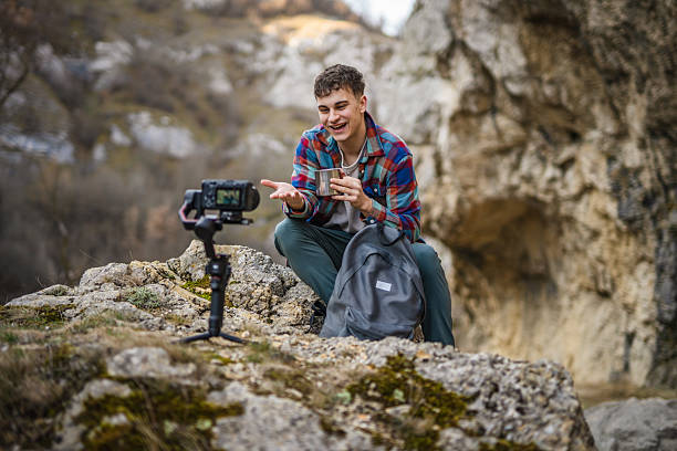istock Man hiker kneel and making video on camera with stabilizer show cup 2204365740
