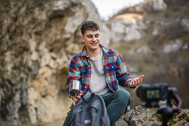 istock Man hiker kneel and making video on camera with stabilizer show cup 2204365818