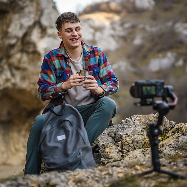 istock Man hiker kneel and making video on camera with stabilizer show cup 2204365853