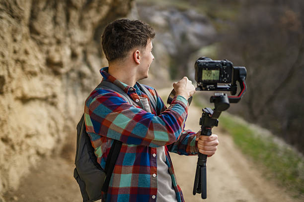 istock Man hiker making video on camera with stabilizer show cup on footpath 2204365932