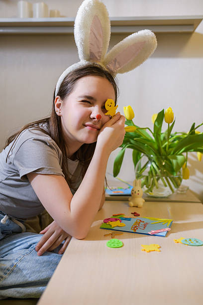 istock Smiling girl in bunny ears holding Easter decoration. 2204366532