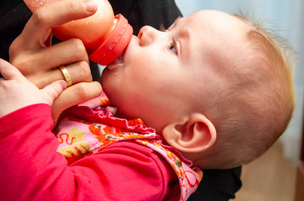 close up of young blond mother Bottle feeding the baby