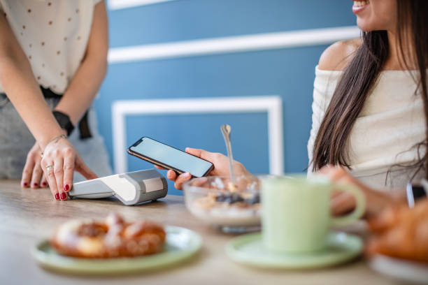 istock Using wireless technology to pay for brunch at a modern restaurant with two young adults 2204368188