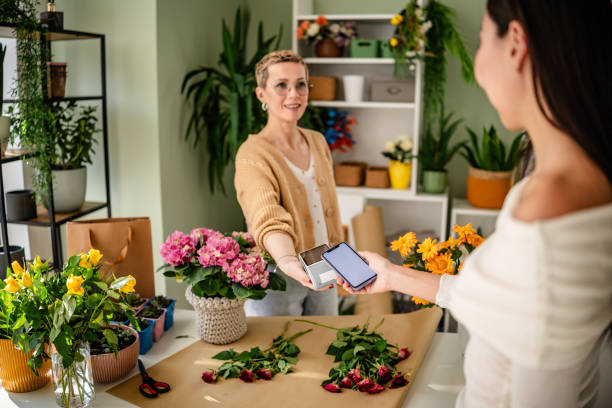 istock Wireless payment at a flower shop while purchasing a bouquet of fresh flowers using modern technology 2204369317