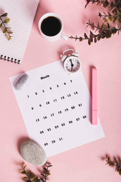 istock Calendar, alarm clock, notebook and pen on a pink background top and vertical view 2204369777