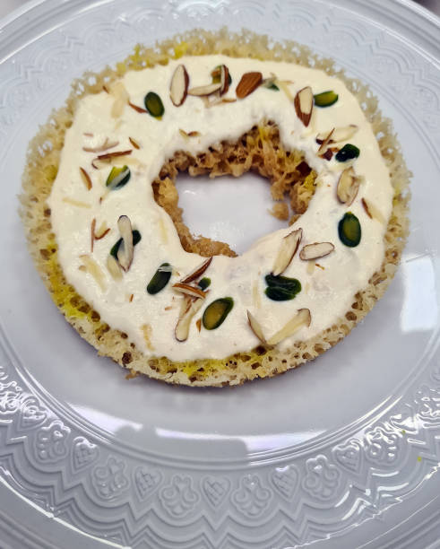 istock Delightful dessert features a crispy base topped with creamy layer, garnished with pistachios and almonds for an exquisite taste 2204371201