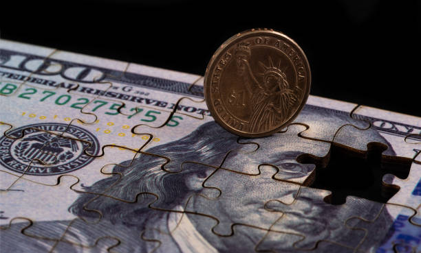 istock US $1 coin and US $100 bill made from puzzles 2204371898