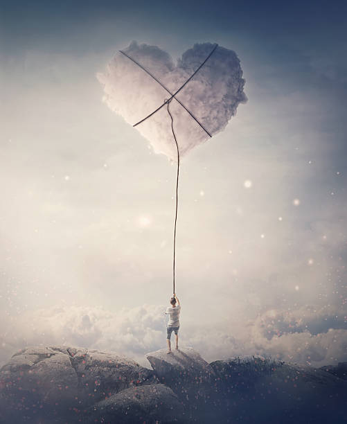 istock Romantic view of a young man, holding a lasso, trying to catch and pull a heart shaped cloud from the sky. Magical scene, love and romance concept 2204373134