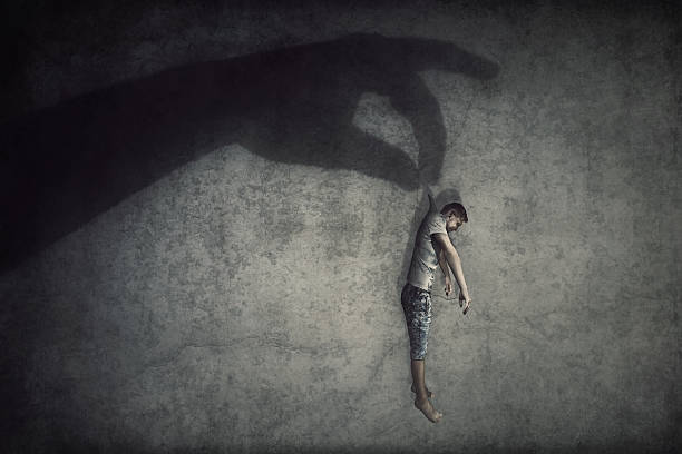istock Human manipulation concept as a big hand shadow holds a powerless man hanging down as a marionette. People control supremacy and dominance metaphor 2204373251