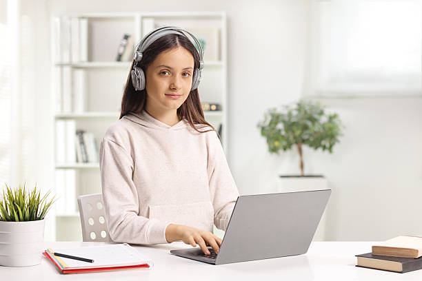 istock Teenage female student with headphones using a laptop computer 2204373612