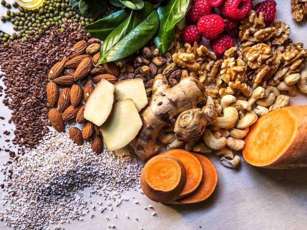 istock Multi colored vegetables, fruits, llegumes and nuts on wooden table 2204376782