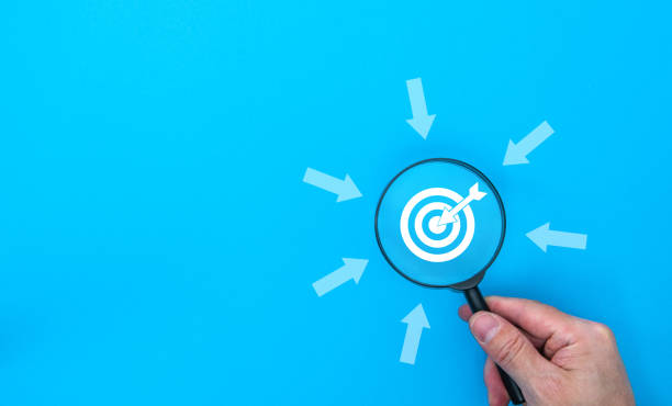 istock Business target concept with magnifying glass and target board on blue background 2204381441