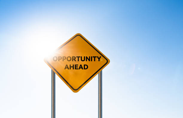 Yellow opportunity ahead road sign post over blue sky