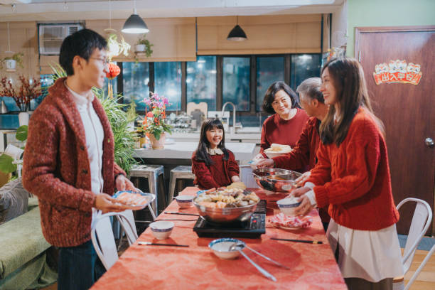 Modern Hong Kong multi-generation family celebrating Chinese New Year. They are preparing for dinner with hotpot and Big Bowl Feast (poonchoi) , a cantonese cuisine