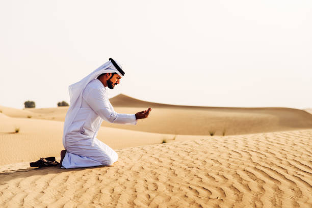 arab man praying on the desert