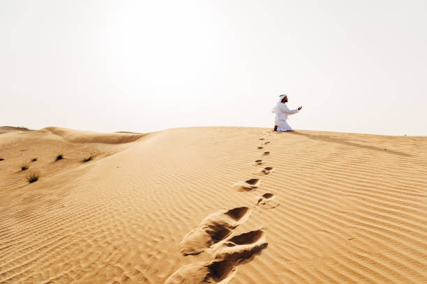 arab man praying on the desert