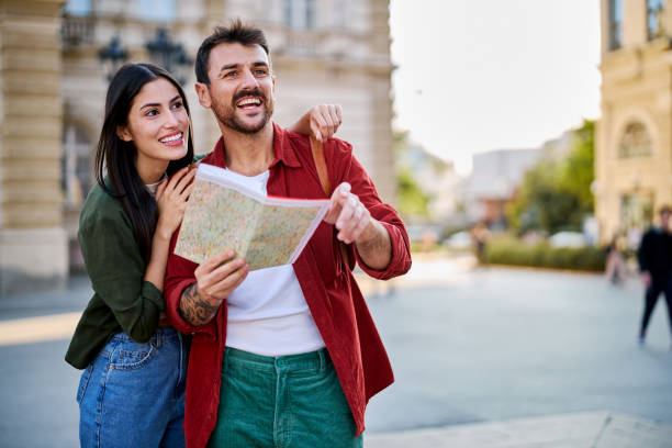 istock Happy couple reading a map and exploring a new city during summer vacation 2204387115