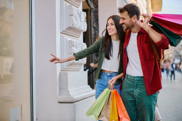 istock Young couple doing shopping and pointing at a shop window 2204387134