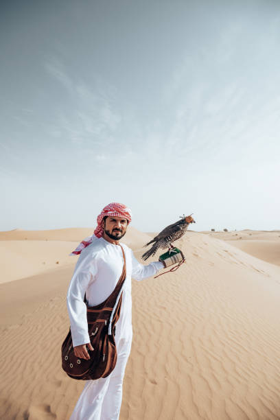 istock arab man with falcon in the desert 2204387655