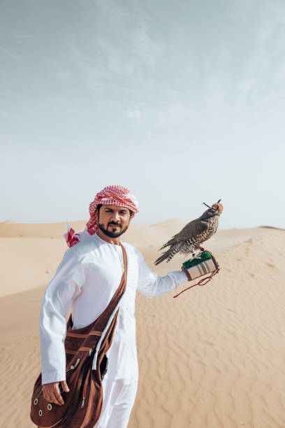 istock arab man with falcon in the desert 2204387693