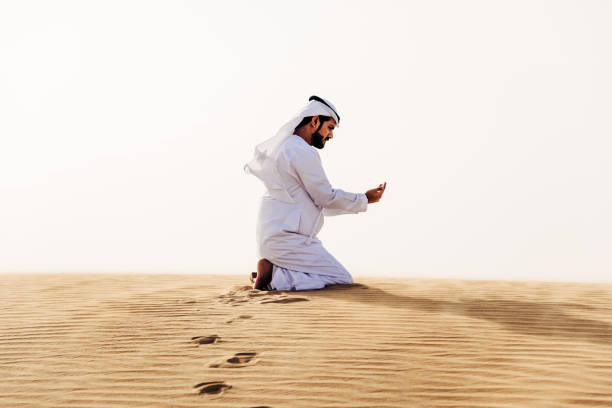 istock arab man praying on the desert 2204388675
