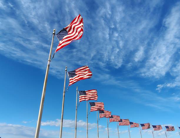 istock semicircle of marican national flags against sky background 2204390472