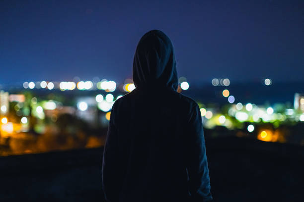 istock Man silhouette at night city background 2204392830