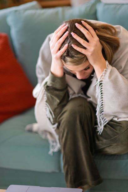 istock A woman in pain takes medication at home. 2204394607