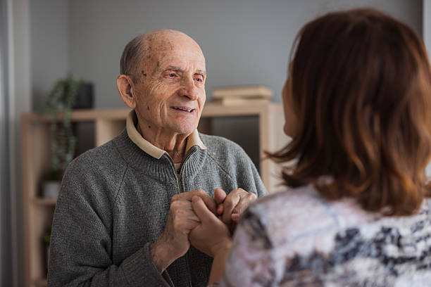 Loving elderly man holding his daughter by the hands