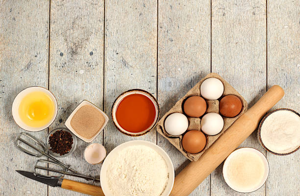 istock Kitchen background of food preparation with space for text. Culinary ingredients for making pie and bread, recipe with eggs, flour, sugar, honey, cinnamon, yeast and butter. Modern bakery concept 2204395229