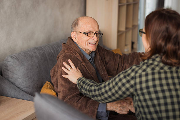 istock Woman visiting elderly man at a nursing home 2204395314