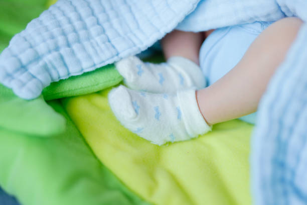 A baby feet in socks lying on a bed