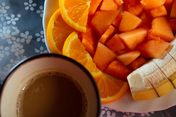 diced melon, orange, banana and latte on a white plate