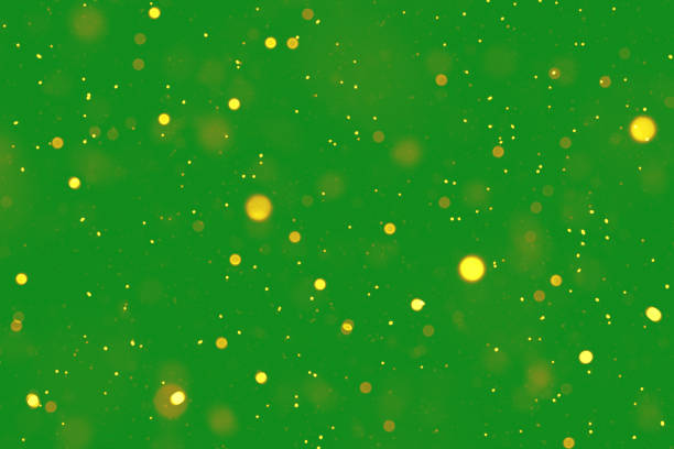 Shimmering golden particles on a green backdrop symbolize celebration, abstraction, and festivity.
