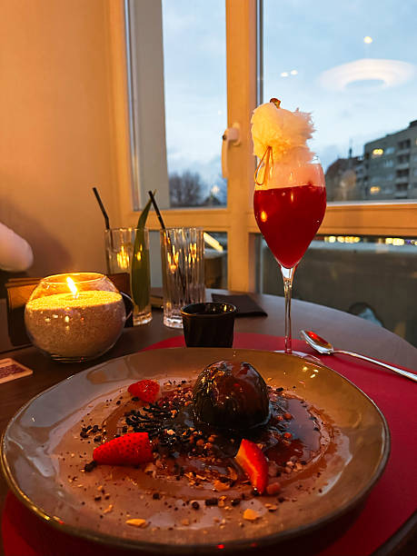 Elegant dining with dessert, drinks, and candlelight by large window