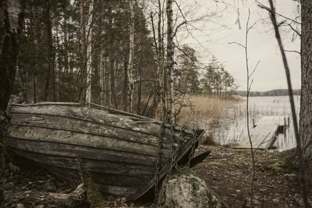An old wooden rowing boat by a lake
