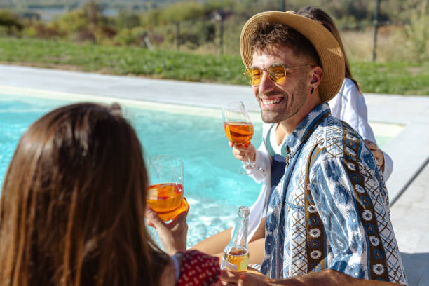 istock Group of friends enjoying drinks by a pool on a sunny day 2204409577