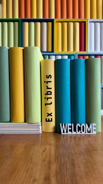 istock Library, colorful generic book spines in shelves, welcome sign on desk 2204410132