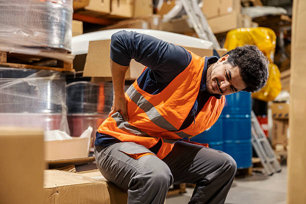 istock Diverse warehouseman in pain having backache and rubbing his spine. 2204410424