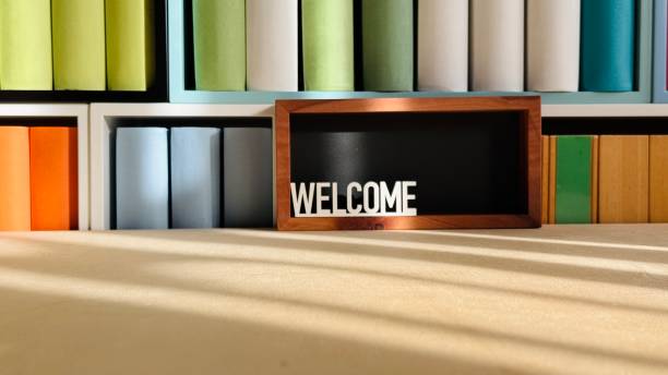 Library, colorful generic book spines in shelves, welcome sign on black background