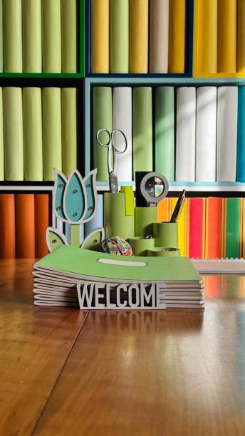 istock Library, colorful generic book spines in shelves, welcome sign and office supply 2204411882