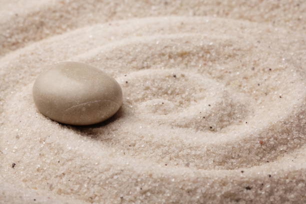 istock zen stone and raked sand - relaxation wabi sabi background 2204412018