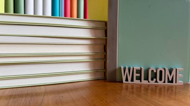 istock Library, colorful generic book spines in shelves, stack of books, welcome sign 2204412160