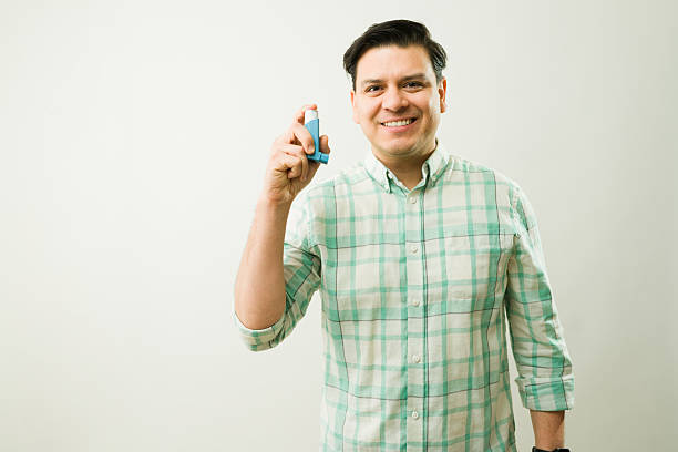 istock Hispanic male smiling, grasping asthma inhaler, representing respiratory wellness and proactive health management 2204413262