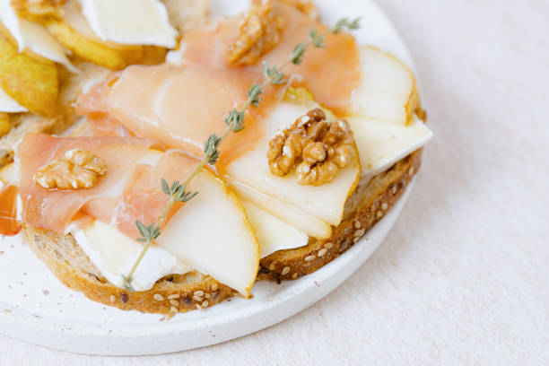 istock Sandwich with cheese, pear and dry-cured slices in a plate. 2204416293